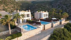 an aerial view of a house with a swimming pool at The Noverian Scenic Crete 5 Star Hilltop Villa Resort & Spa in Malia
