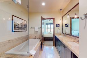 Un baño con bañera y dos lavabos y ducha. en Bangtail Getaway, en Steamboat Springs 21 fotos más