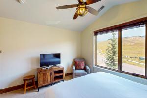 Un dormitorio con una cama y un televisor y una ventana. en Bangtail Getaway, en Steamboat Springs