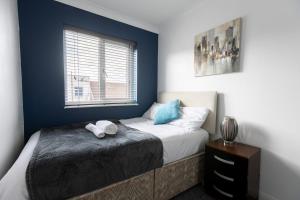 una camera da letto con un letto e una finestra di Hullidays - 'Old School Penthouse' Trinity Square a Hull