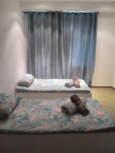 duas camas em um quarto com janela em Suíte candelária no Rio de Janeiro mais 2 fotografias