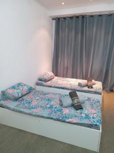 duas camas individuais num quarto com almofadas e aversão em Suíte candelária no Rio de Janeiro