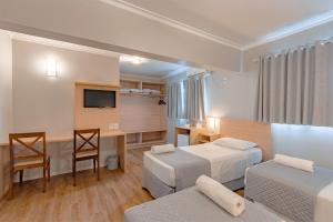 ein Hotelzimmer mit zwei Betten und einem Schreibtisch in der Unterkunft Bristol Sabrina Hotel de Charme Joinville in Joinville