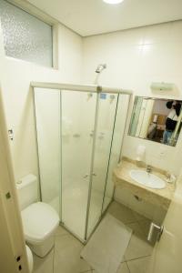 a bathroom with a shower and a toilet and a sink at CHA Mime Hotel in Blumenau +63 photos