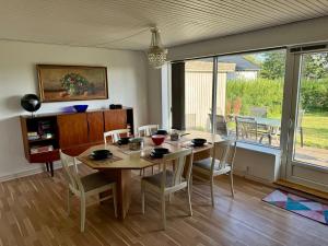 a dining room with a table and chairs and a window at Nice house in the countryside with a view in Agerskov