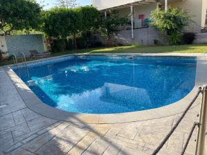a swimming pool with blue water in a yard at Turquoise Front Sea Apartment in Kokkíni Khánion