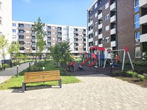 a park with a bench and a playground at Moderan i stilski apartman - miran deo Novog Sada in Novi Sad