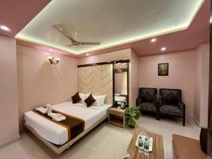 a bedroom with a large bed and a table at The Little Heaven Hotel near Kolkata Airport in kolkata