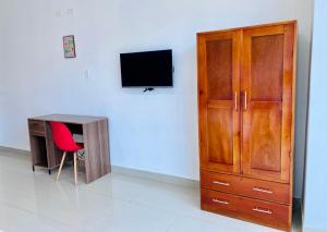 a room with a desk and a cabinet and a television at Departamento Céntrico de Estreno en Pucallpa in Pucallpa