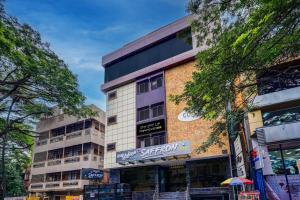 a building on a city street with trees at Super Townhouse OAK Clove Boutique Hotel Rajaji Nagar Near Lulu Mall Bengaluru in Bengaluru