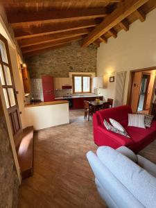 a living room with a red couch and a kitchen at La casa di Bianca b&b in Collagna
