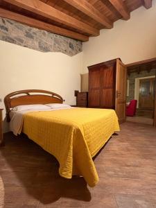 a bedroom with a bed with a yellow bedspread at La casa di Bianca b&b in Collagna +22 photos