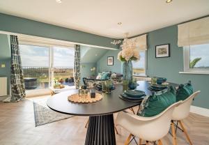 a dining room with a table and chairs at Priory Bay Escapes - Alba in Tenby