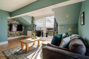 a living room with a couch and a table at Priory Bay Escapes - Alba in Tenby