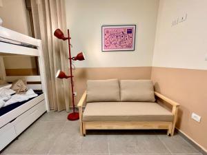 a room with a bed and a bench in a bedroom at 3BR Gem Steps from Shuk Machne Yehuda in Jerusalem