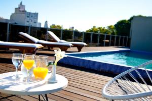 a table with two glasses of orange juice and a flower on it at First Palermo Hotel in Buenos Aires