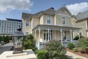 ein gelbes Haus mit einer Straßenlaterne davor in der Unterkunft The 200 South St | King Ste 24 in Charlottesville