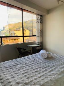 a bedroom with a bed and a large window at Hostal El Mariscal in Urubamba