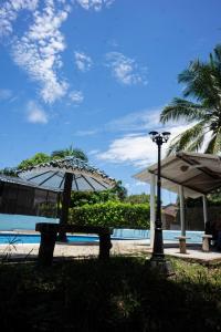 a bench with an umbrella next to a pool at La Juanita in Melgar