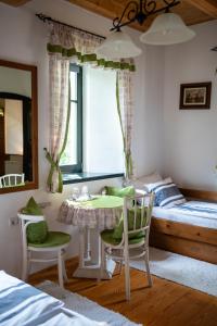 a bedroom with a bed and a table and chairs at Guest House Vidravar in Tabdi