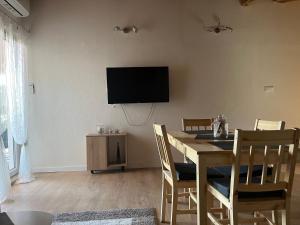 comedor con mesa y TV en la pared en Apartmani Matković, en Žuljana