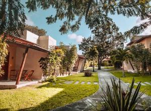 a courtyard of a house with trees and grass at Oka Káa - Bosque da Praia Pipa Flat 33 in Pipa