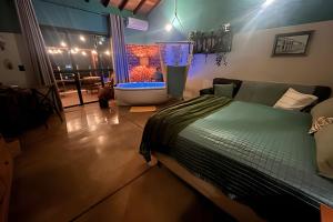 a bedroom with a bed and a tub in a room at Chalé Cabana c/ Hidro, Vista e Superhost -Jundiaí in Jundiaí