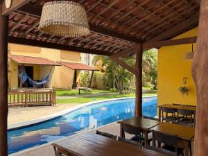 a patio with tables and a swimming pool at Oka Káa - Bosque da Praia Pipa Flat 33 in Pipa