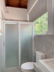 a bathroom with a toilet and a glass shower door at Nature's Hideaway in Anuradhapura +71 photos