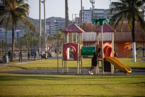 a child playing on a playground in a park at 250m do Mar | Piscina e Roupas de Cama in Bertioga