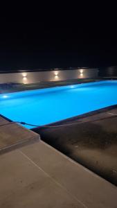 a swimming pool at night with blue lights at Diamona Lux Apartman 1 in Donja Toponica