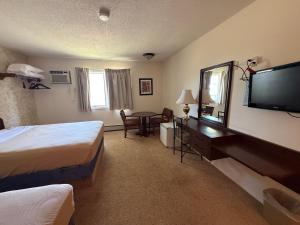 Una habitación de hotel con dos camas y un televisor. en Hotel O The Kings Inn Culberston MT HWY 2, 