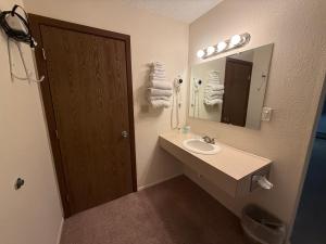 un baño con lavabo y espejo en Hotel O The Kings Inn Culberston MT HWY 2,  37 fotos más