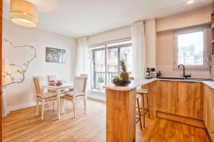 een keuken en eetkamer met een tafel en stoelen bij Le Morny Palace - Hyper Centre in Deauville