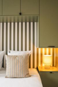 een slaapkamer met een bed met een gestreept hoofdeinde en een lamp bij Le Morny Palace - Hyper Centre in Deauville
