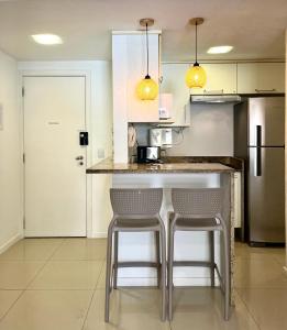 a kitchen with two stools at a kitchen counter at Ocean View - Camboinhas Beach I 214B in Niterói