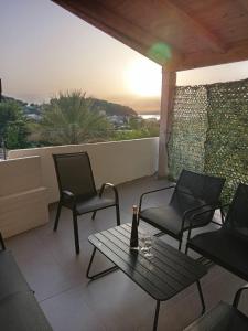 Un patio con sillas y una mesa con una botella de vino. en Apartmani Matković, en Žuljana