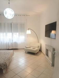 ein Wohnzimmer mit einem Bett, einer Couch und einem Fernseher in der Unterkunft La Finestra sulla Storia in Asti