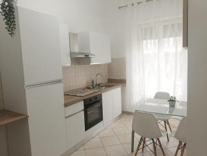 a kitchen with white appliances and a table and chairs at La Finestra sulla Storia in Asti