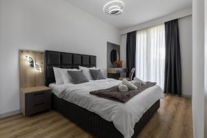a white bedroom with a large bed and a window at 20th Floor Amazing View, Spa & Fitness Parking APT in Skopje