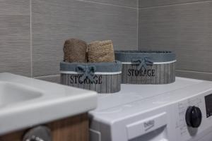 two baskets sitting on top of a washing machine at 20th Floor Amazing View, Spa & Fitness Parking APT in Skopje +7 photos