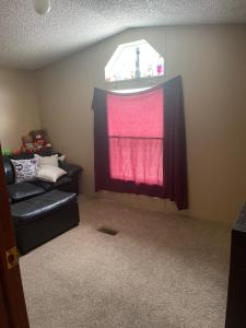 a living room with a black couch and a window at Valleybrook in Indianapolis