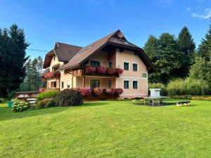 a large house with a lawn in front of it at Ferienwohnung Petritz in Velden am Wörthersee