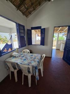 サン・フランシスコ・デ・イタバポアナにあるCasa de praia pet friendly muito aconchegante a dois minutos da praia!のダイニングルーム(テーブル、椅子付)、窓のある部屋
