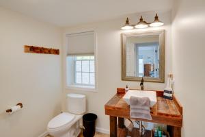 a bathroom with a sink and a toilet and a mirror at Fire Pit and Views Crooked Lake Group Getaway! in Averill Park +26 photos
