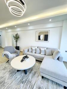 a living room with a couch and a table at Cozy Apartment, 2 bedrooms, 2 bathrooms, Rooftop swimming, Full packed GYM, and workplaces in the Heart of Westlands, Nairobi in Nairobi