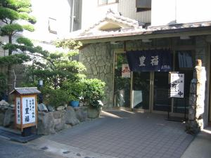 un edificio con un cartello di fronte di Toyofuku a Kobe