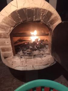 a brick oven with a fire in it at Zona de Camping Hostal Las Hamacas in Villamaría +19 photos
