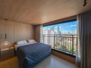 a bedroom with a bed and a large window at Flat Requinte e Aconchego in Campo Grande +15 photos