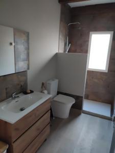 a bathroom with a sink and a toilet and a window at Cesarina Urban Rural House in Chantada +13 photos
